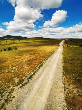 Güneşli yaz gününde yeşil Zlatibor tepelerinin üzerinden güzel beyaz bulutlar süzülüyor. Popüler Sırp turistler yüksek açılı manzarayla seyahat ediyorlar.