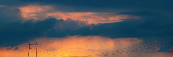 全球能源危机概念 以架空电力电缆和暴雨云彩为背景的输电塔电塔塔塔为背景 凸显了电力供应的不确定性 — 图库照片