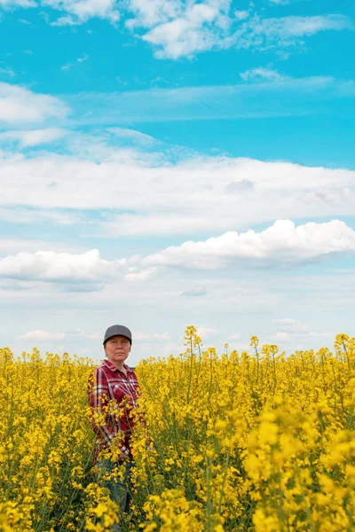 Pracovnice Farmy Červeném Kostkovaném Tričku Klobouku Kamioňáka Stojící Kvetoucím Obdělávaném — Stock fotografie