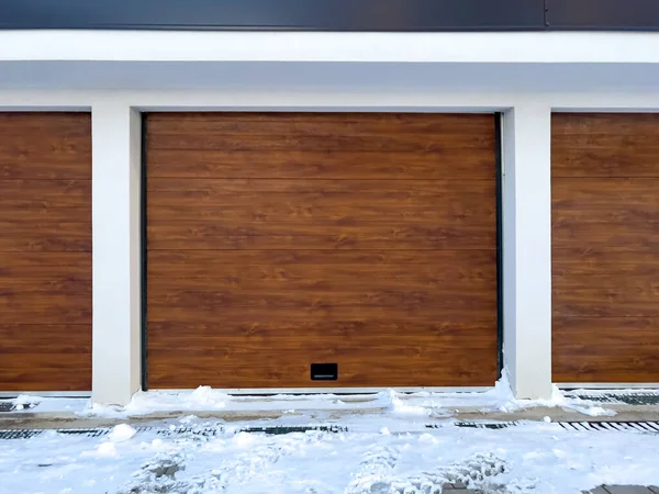 Car garage door in winter with snow and ice in front