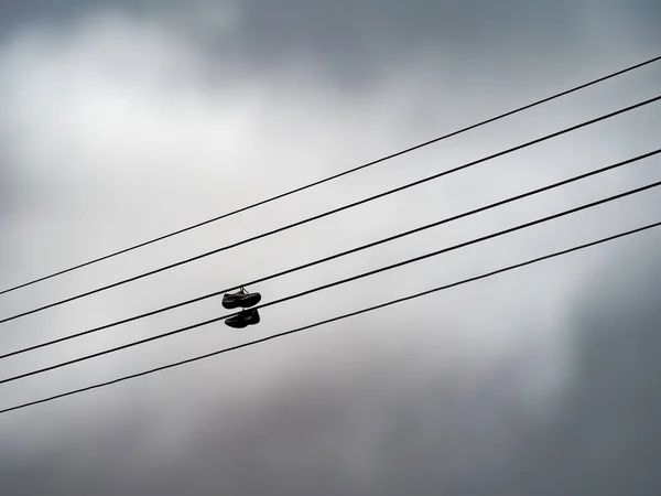 Unidentifiable Old Pair Trainers Shoes Telephone Wires Silhouette Sky 图库照片