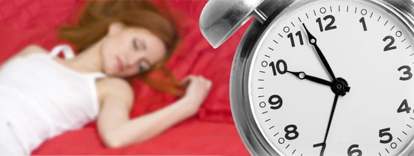 Reloj despertador y mujer joven dormida —  Fotos de Stock