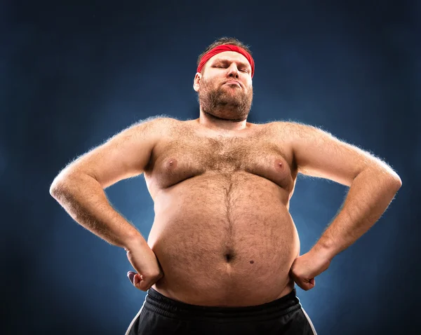 Homem gordo imitando a construção muscular — Fotografia de Stock