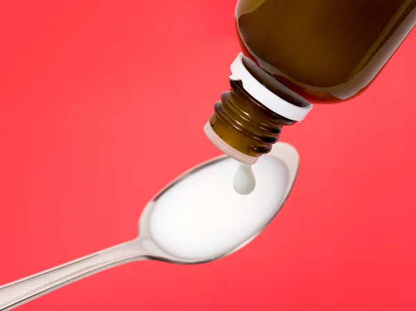 Liquid medicine dropping on a spoon — Stock Photo, Image