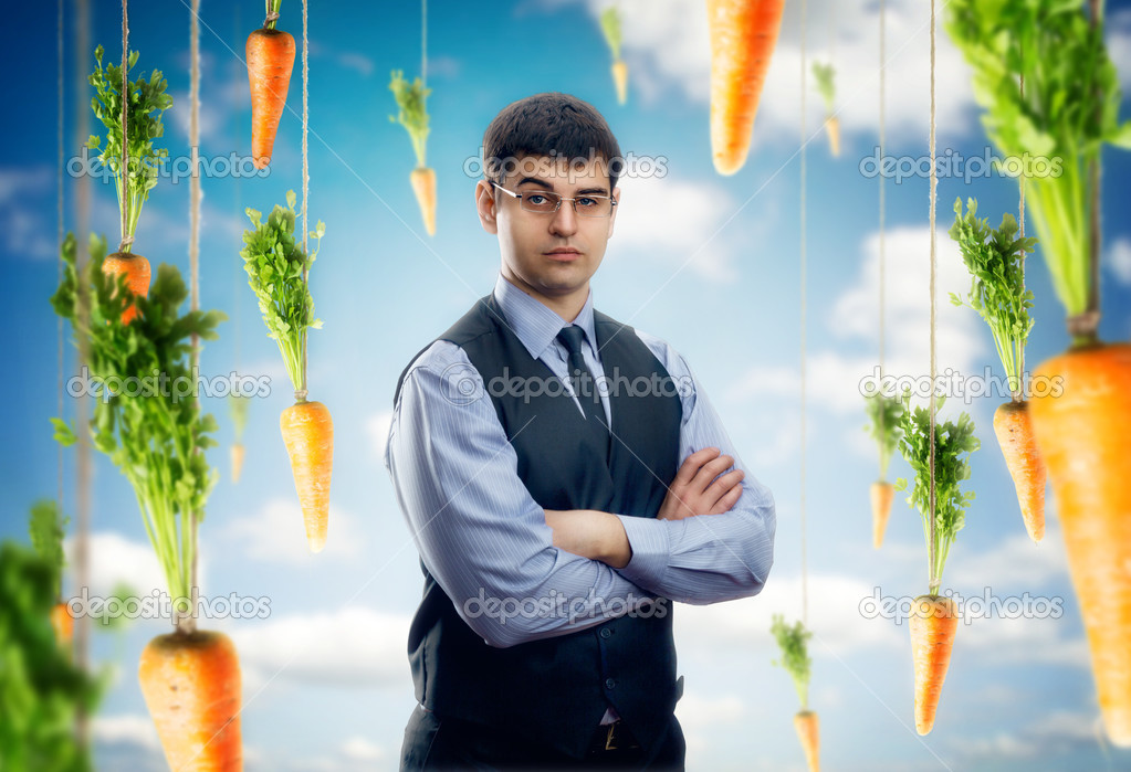Businessman against blue sky with red carrots