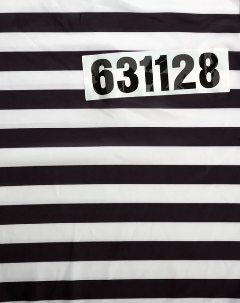 Смугасте плаття для в'язнів і номер — стокове фото