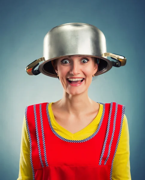 Happy housewife with sause pan on her head — Stock Photo, Image