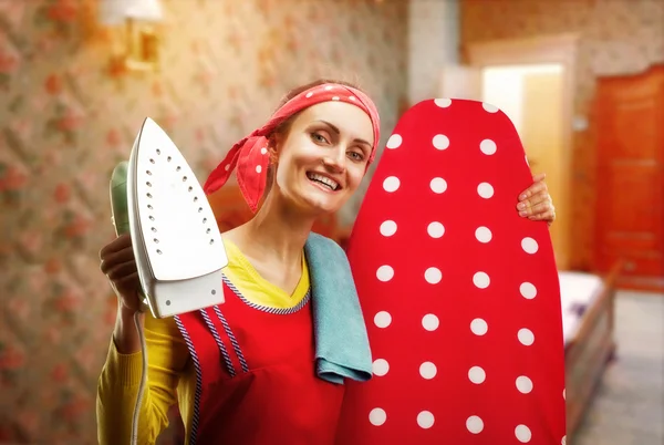 Smiling housewife with ironing-board and iron — Stock Photo, Image