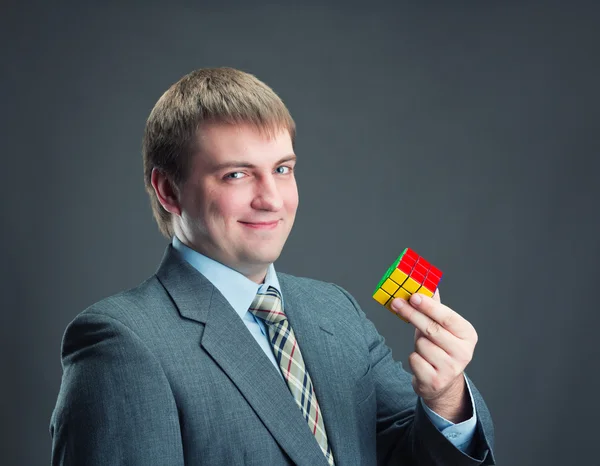 Üzletember holding rubik kocka — Stock Fotó