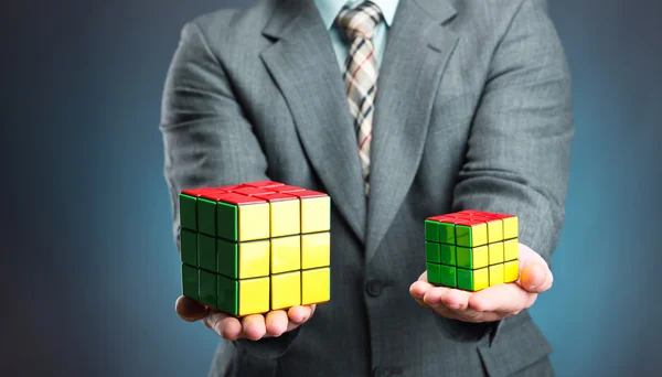 Empresário segurando cubo de rubik — Fotografia de Stock