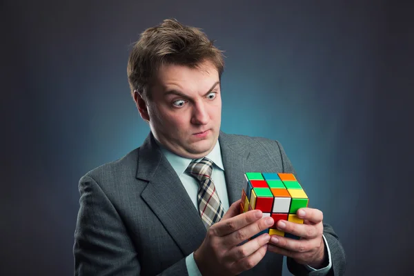 Empresario sosteniendo cubo de Rubik — Foto de Stock