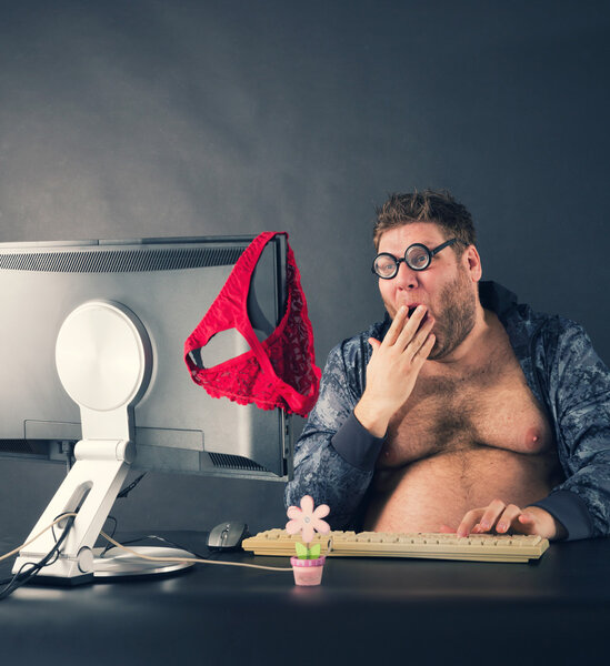 Человек сидит за столом и смотрит на экран компьютера
