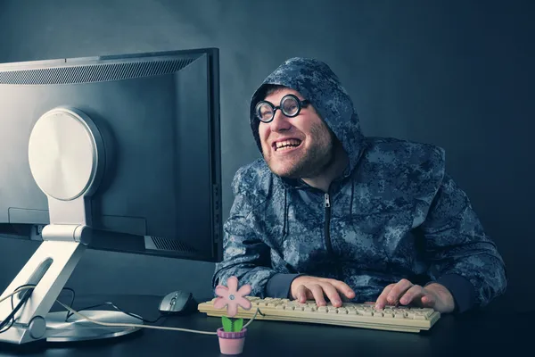 Mann sitzt am Schreibtisch und schaut auf Computerbildschirm — Stockfoto