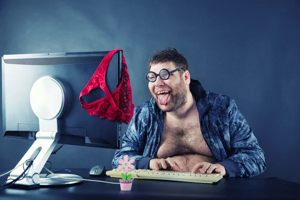 Ο άνθρωπος που κάθεται στο γραφείο και να βλέπω στην οθόνη του υπολογιστή — Φωτογραφία Αρχείου