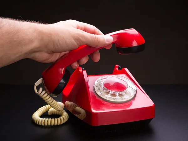 Telefone vermelho auscultador na mão — Fotografia de Stock