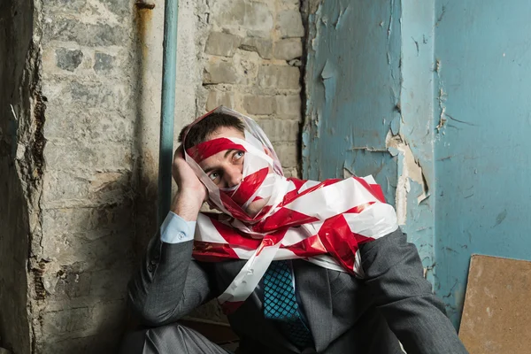 Man with stripped duct tape over body in old house — Stock Photo, Image