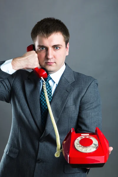 Portrait of a man speaking phone isolated on gray — Stock Photo, Image