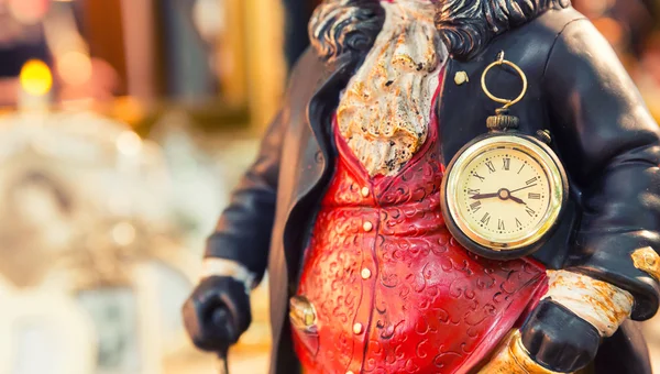 Ancient style clock on the statuette of man — Stock Photo, Image