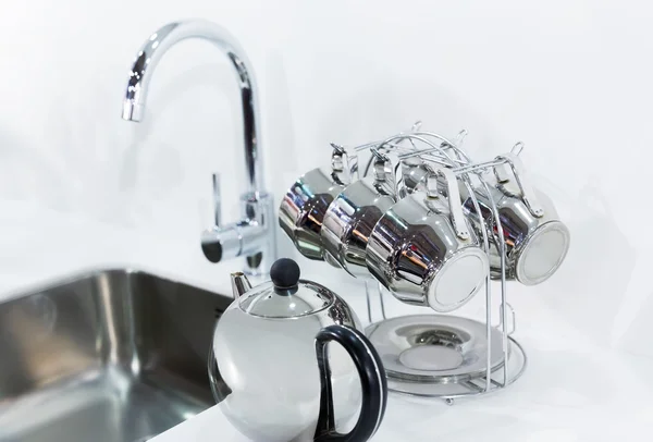 Cups drying near metal sink — Stock Photo, Image