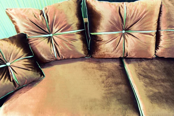 天鹅绒的棕色的沙发上的枕头 — 图库照片