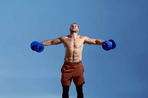 Atleta muscular masculino com halteres em estúdio — Fotografia de Stock