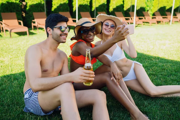 Fröhliche Freunde trinken Bier am Pool — Stockfoto