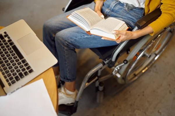 Behinderte Studentin hält ein Buch in der Hand, Draufsicht — Stockfoto