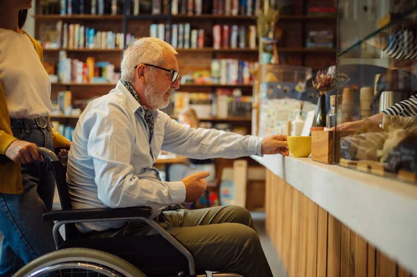 Handicapped older man and young female guardian