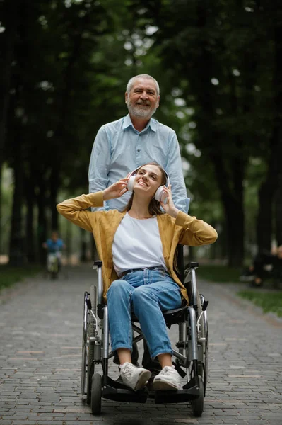 Apa rokkant lánnyal sétál tolószékben. — Stock Fotó