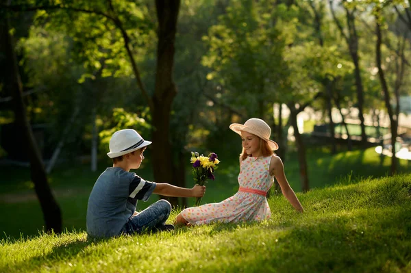 Kinder-Date, Junge überreicht Blumenstrauß an ein Mädchen — Stockfoto