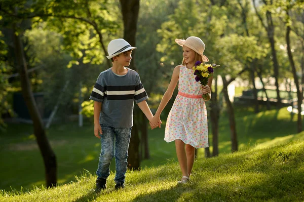 Childrens date, boy and girl with bouquet — Stock Photo, Image