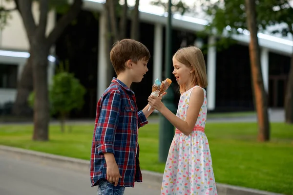Chłopiec i dziewczyna wymieniają lody, daty dla dzieci — Zdjęcie stockowe
