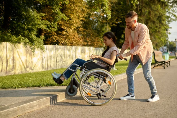 Ehepaar mit Rollstuhl überwindet Bordstein — Stockfoto