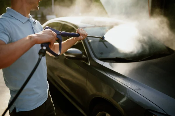 El hombre tiene pistola de agua de alta presión, lavado de autos a mano — Foto de Stock