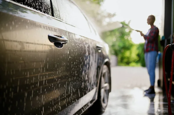 女人洗掉车上的泡沫，用手自动洗 — 图库照片