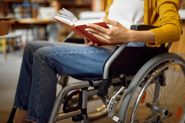 Mozgássérült tanuló kerekesszékben könyvet olvas — Stock Fotó
