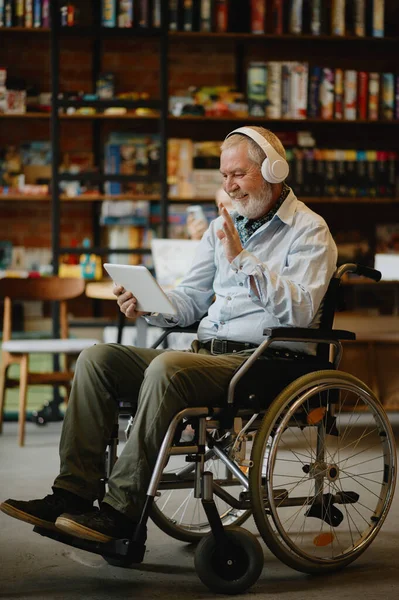 Felnőtt mozgássérült férfi tolószékben zenét hallgatni — Stock Fotó