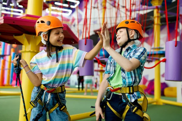 Zwei Kinder mit Helmen klettern auf Seilrutsche — Stockfoto