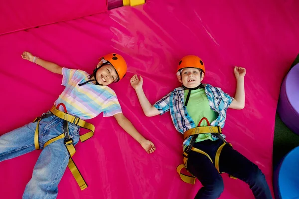 Niños en cascos acostados en esteras, jóvenes escaladores — Foto de Stock