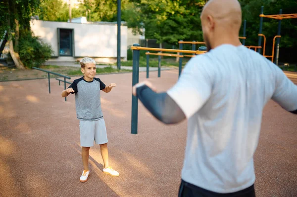 Vader en zoon, sport training op de speelplaats — Stockfoto