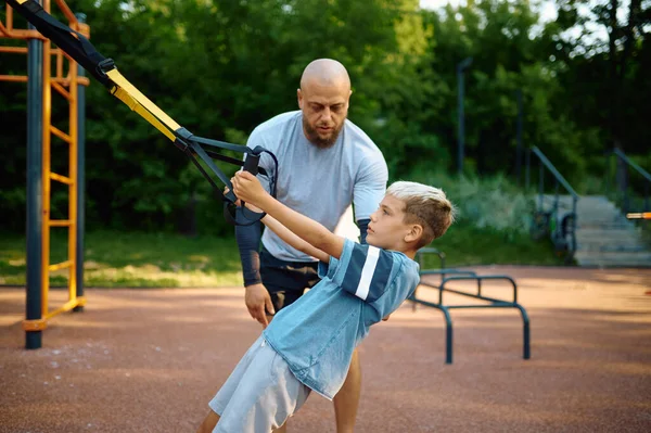 Vader en zoon, oefening met touwen op de speelplaats — Stockfoto