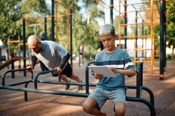 Papa en jongen op de trainingsmachine, sport training — Stockfoto