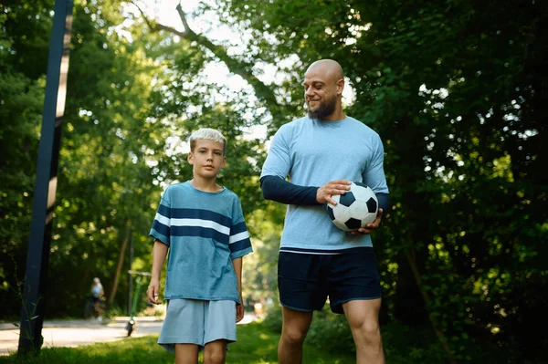 Baba ve oğul güneşli bir günde futbol oynuyorlar. — Stok fotoğraf