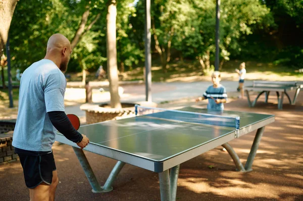 Father and son play table tennis outdoors — Stock Photo, Image