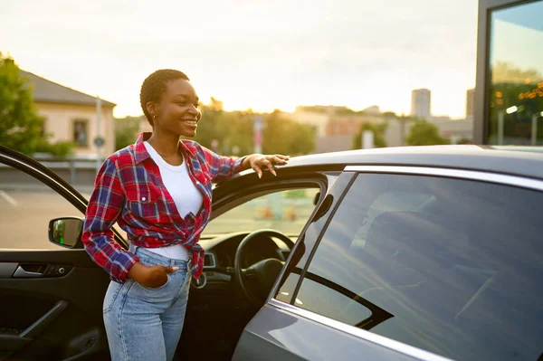 Mujer posa en el coche limpio, la mano de la estación de lavado automático — Foto de Stock