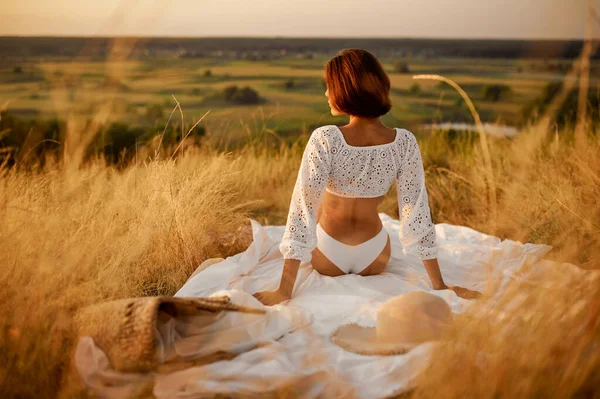 Mujer en lencería blanca sobre manta en el campo — Foto de Stock
