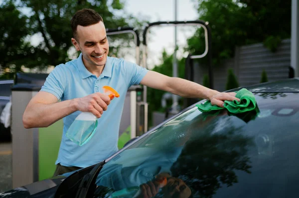 Hombre usando limpiador de ventanas y un trapo, lavado automático a mano — Foto de Stock