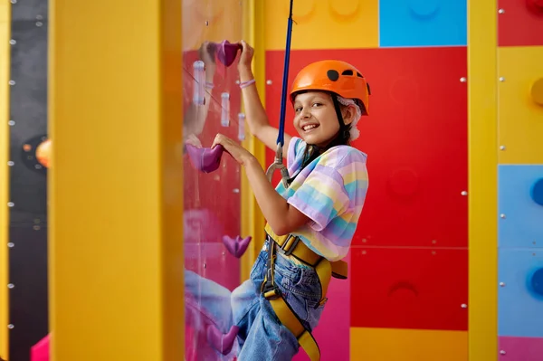 Mała dziewczynka w kasku pozuje na ściance wspinaczkowej — Zdjęcie stockowe