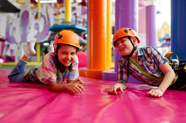 Niños en cascos acostados en esteras, jóvenes escaladores —  Fotos de Stock