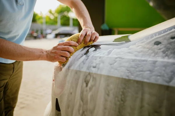 Hombre usando esponja con espuma, lavado de autos a mano — Foto de Stock